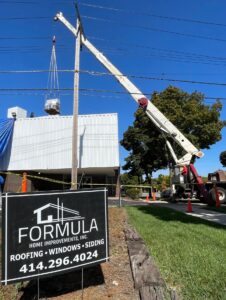 Formula sign in front of a commercial building having a new roof installed